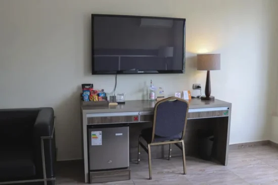 Escritorio con TV y nevera de la suite Rado Hotel Quintanas Trujillo